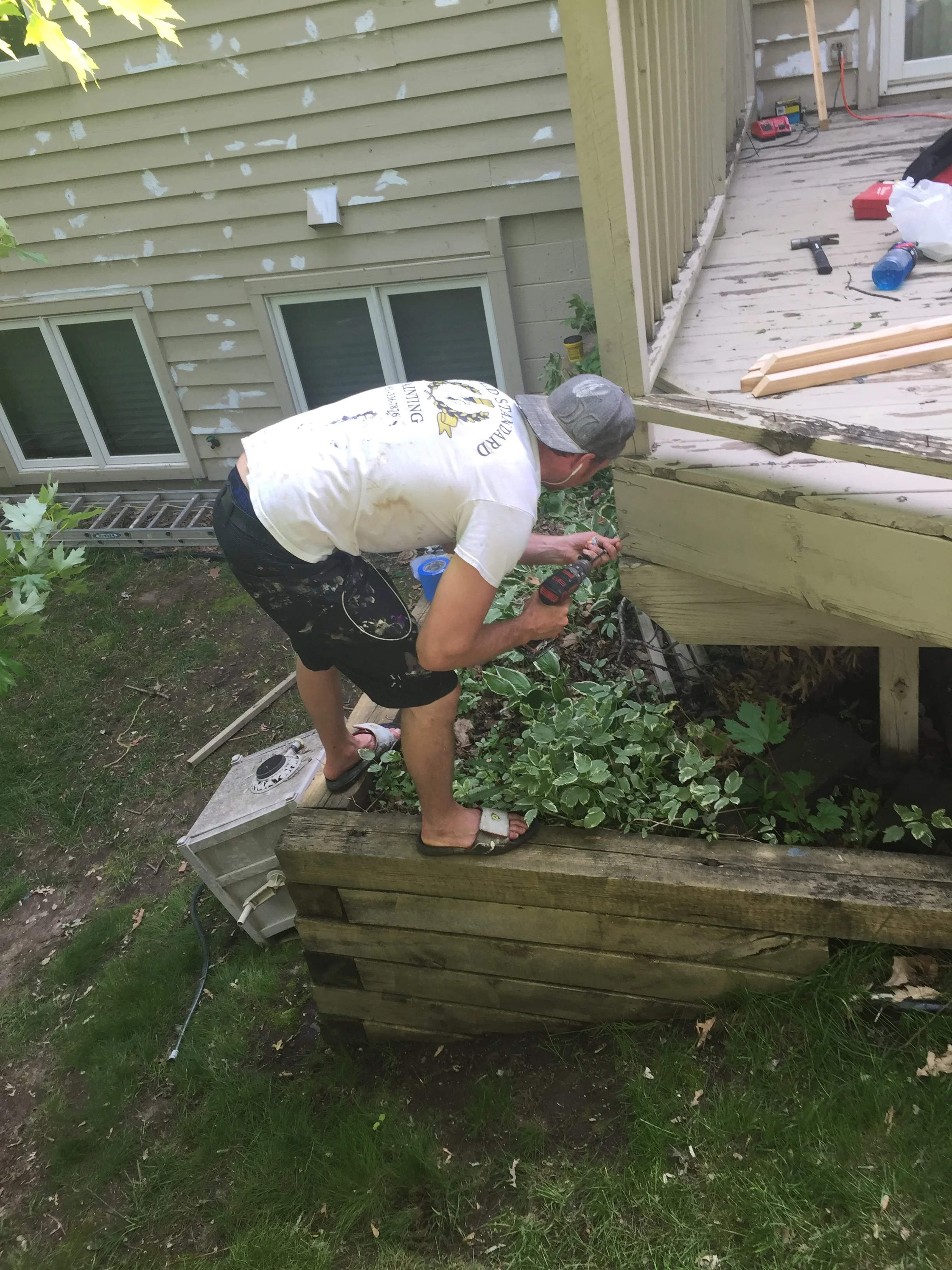 Contractor repairing pressure-treated deck frame and structural components