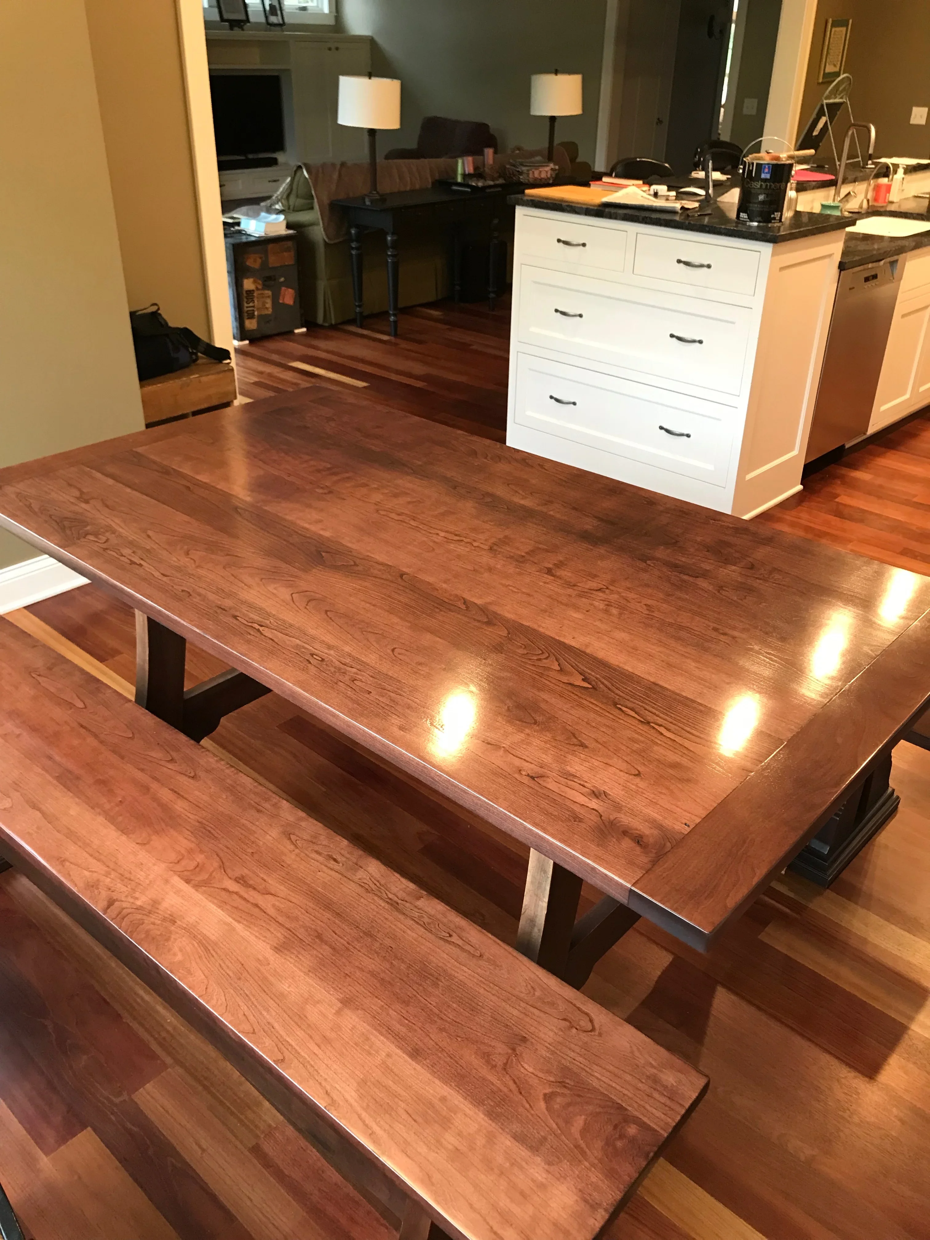 Walnut wood dining table with embedded LED lights and dark wood pedestal base, matching bench seating