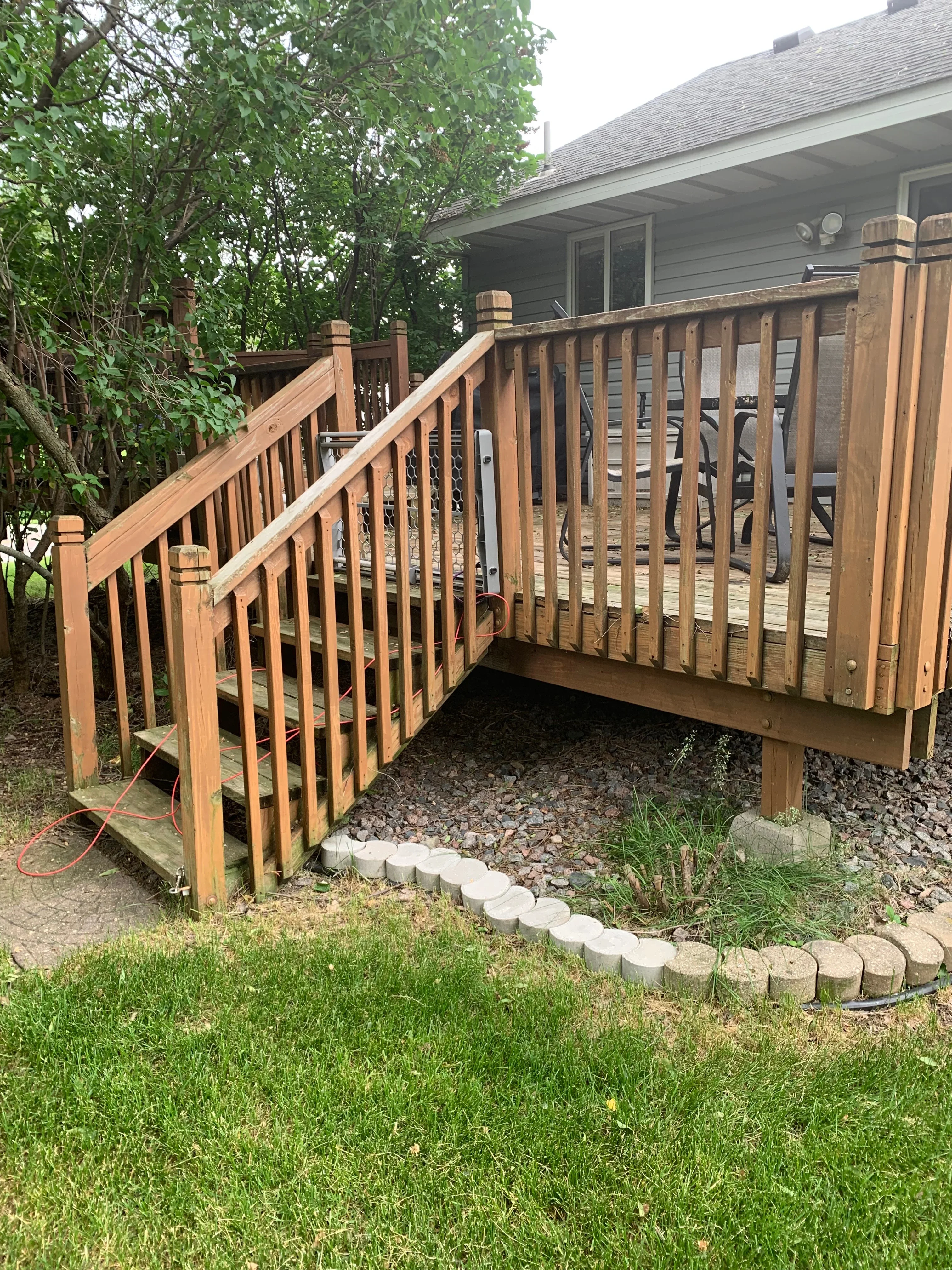 Cedar deck with stained railings, vertical balusters, and horizontal rails attached to residential home