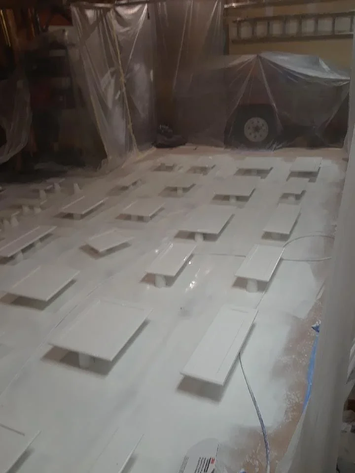 Drywall ceiling with taped seams, access panels, and plastic containment sheeting