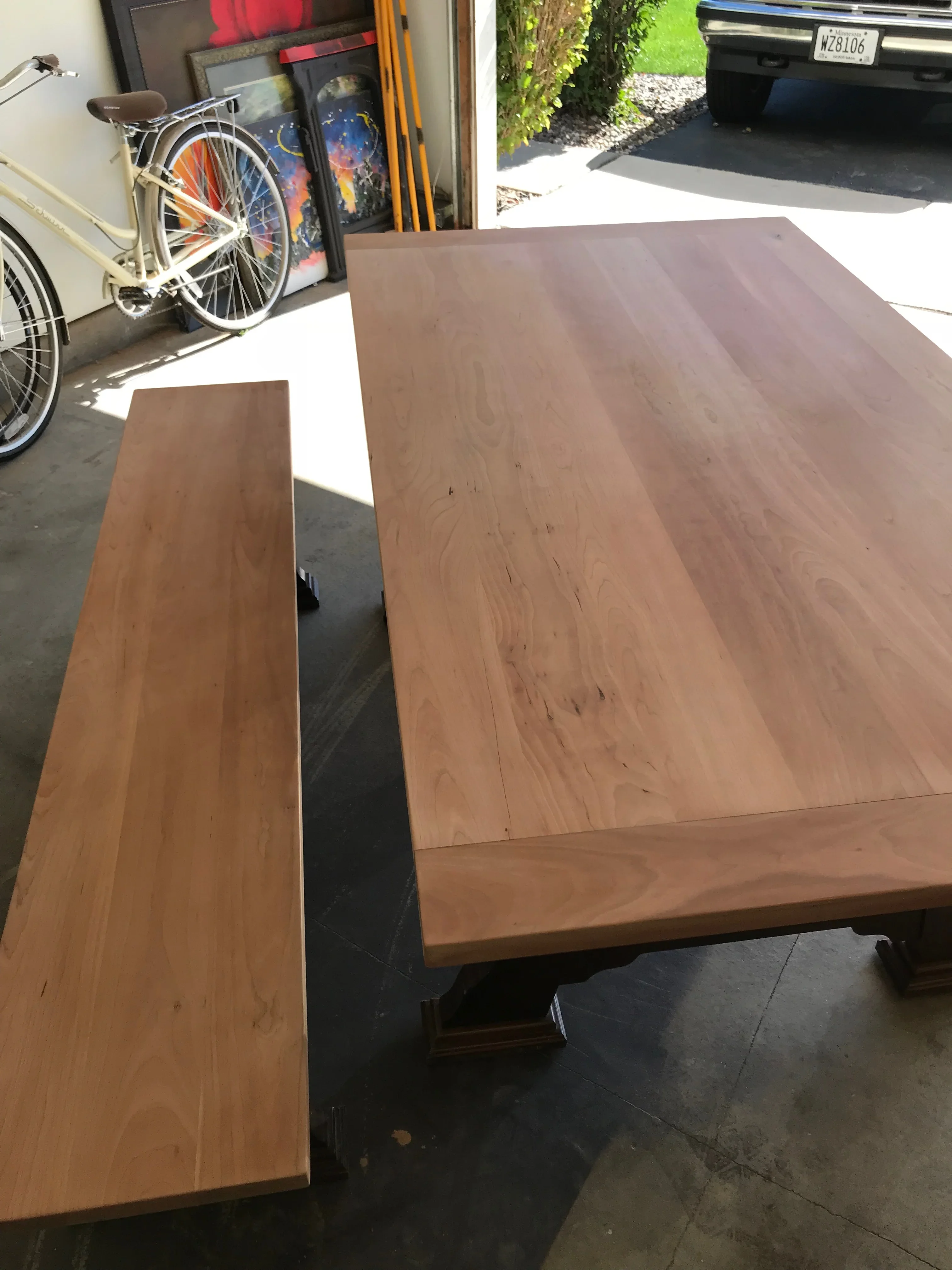 Refinished hardwood table and bench with medium-brown stain on solid wood surfaces