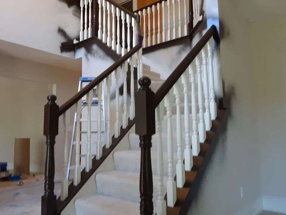 Dark wood handrails with white painted balusters on multi-level interior staircase
