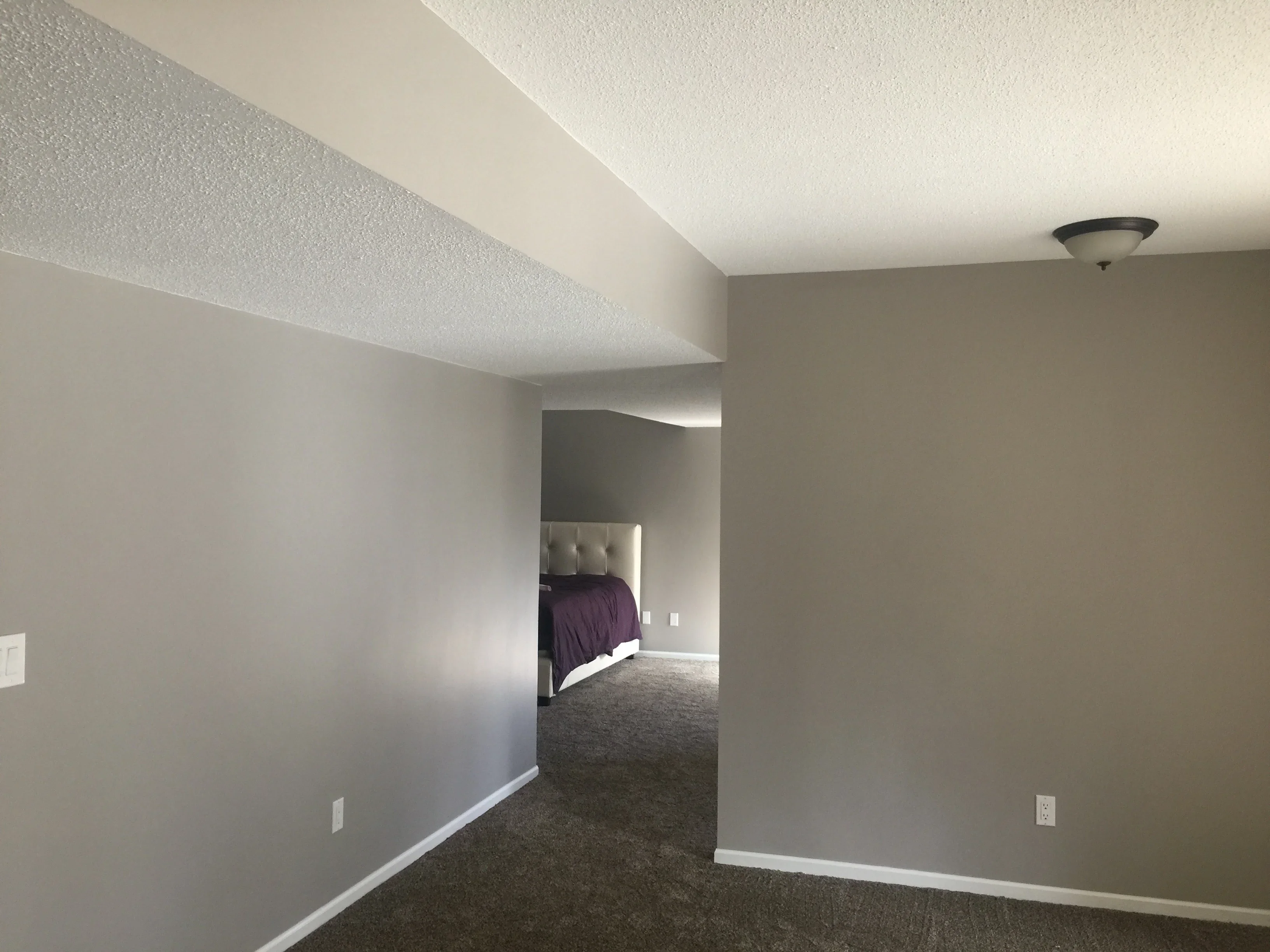 Taupe and white painted bedroom with textured ceiling and white trim