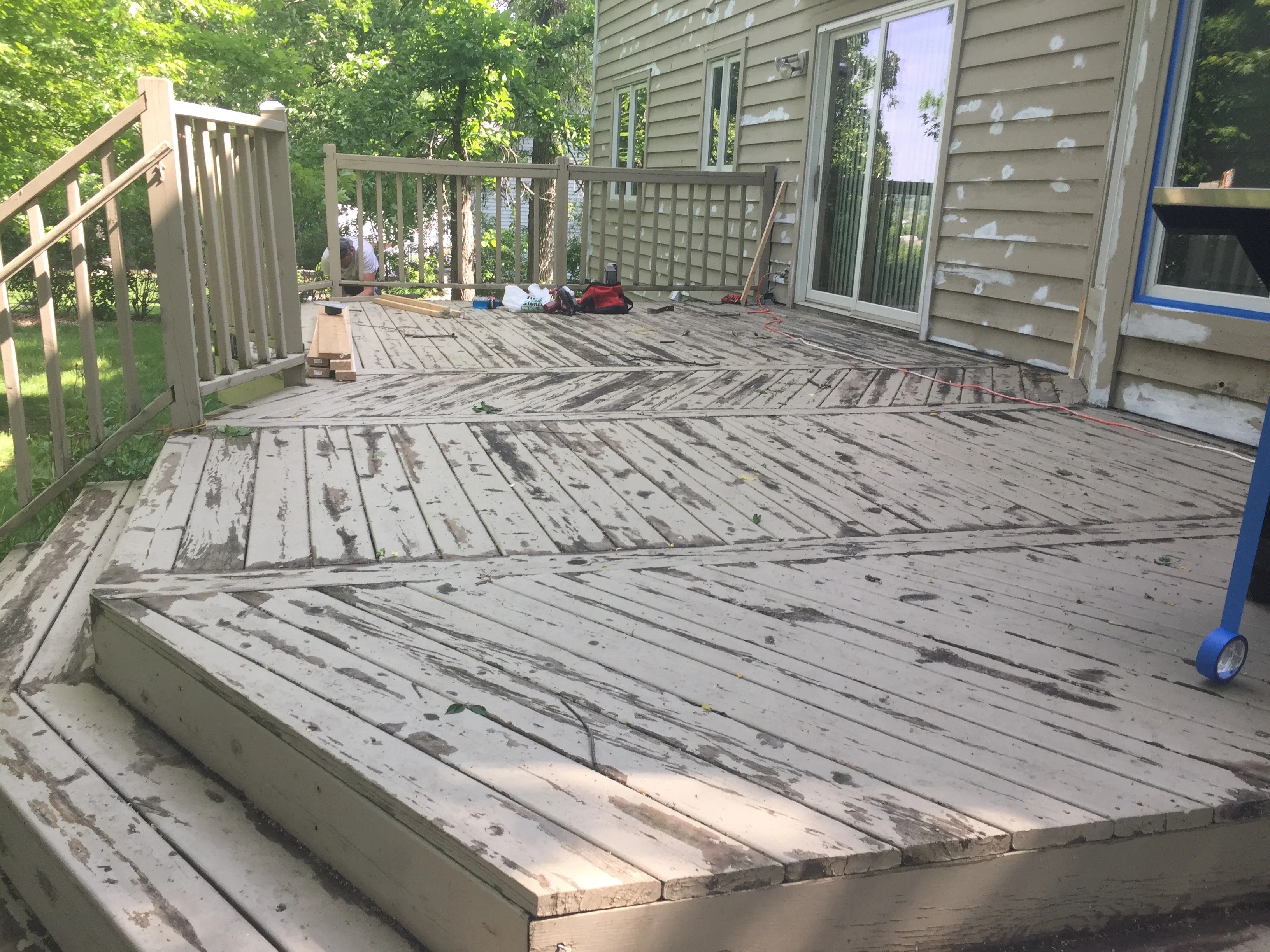 Weathered deck with stripped boards and composite steps during refinishing restoration